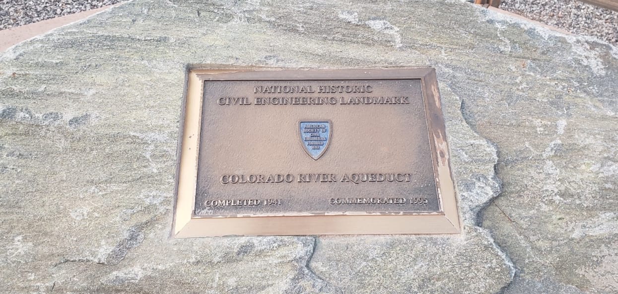 A bronze plaque set into desert stone reading 'National Historic Civil Engineering Landmark — Colorado River Aqueduct, Completed 1941, Commemorated 1995.'