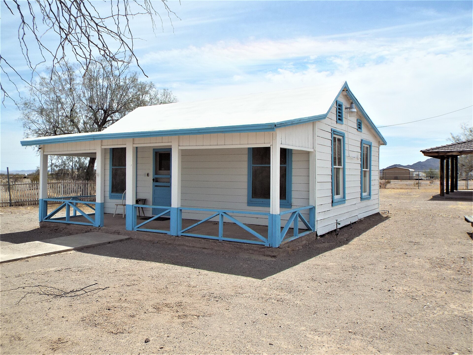 A second present-day view of the Wyatt Earp Cottage in Vidal, California, showing the porch and desert surroundings.