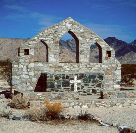 A stone altar built by soldiers at the Desert Training Center, still standing in the open desert against the mountains near Vidal.