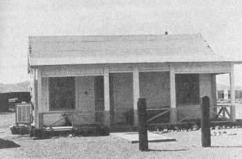 A black-and-white photograph of the small single-story Earp cottage in Vidal, with a covered porch and hitching posts out front.