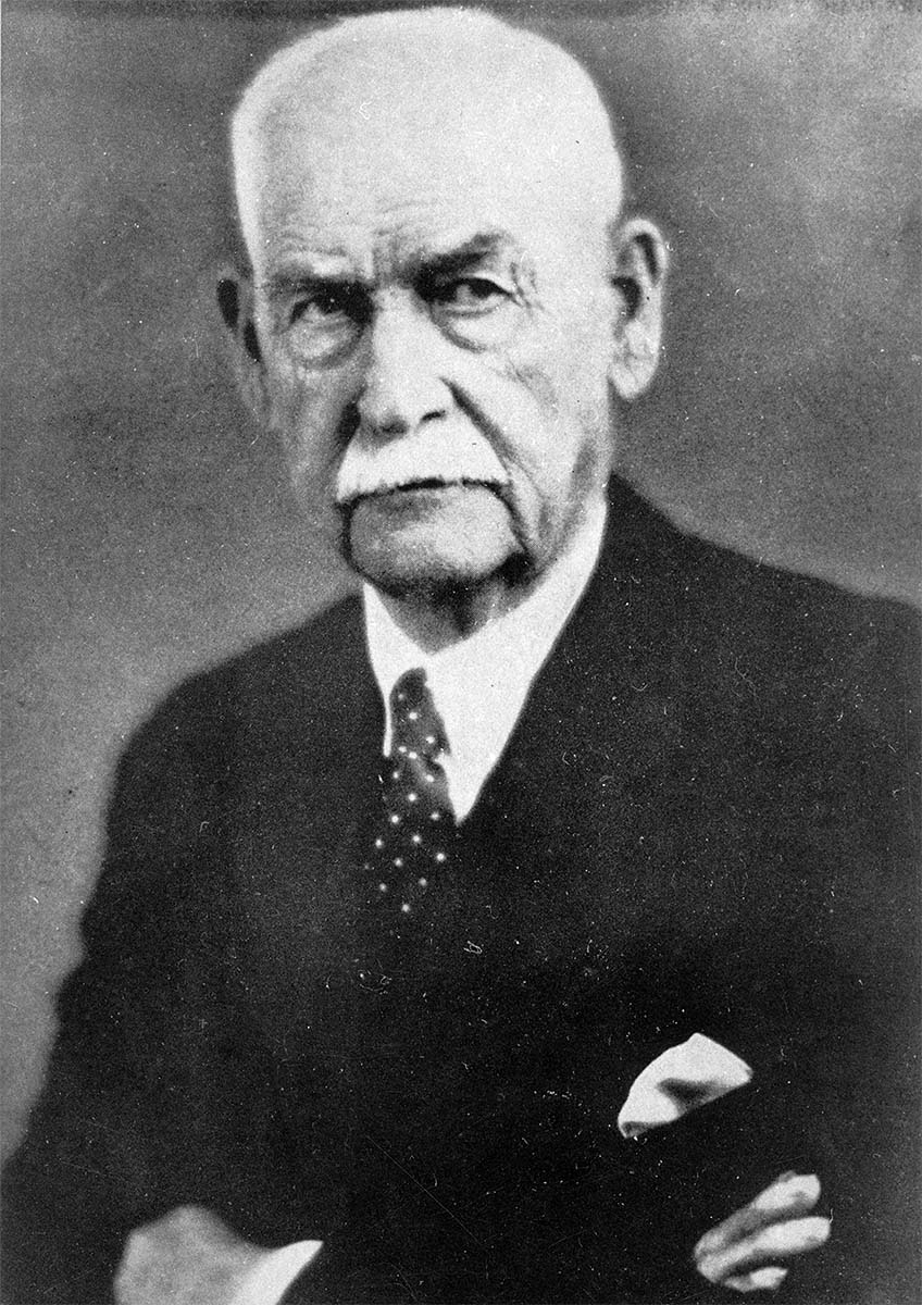 High-resolution archival portrait of Wyatt Earp at about age 80, in a dark suit and tie.