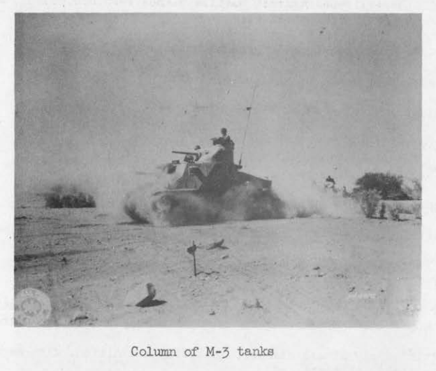 An M-3 light tank speeding across open desert during a Desert Training Center maneuver, kicking up a heavy plume of dust.